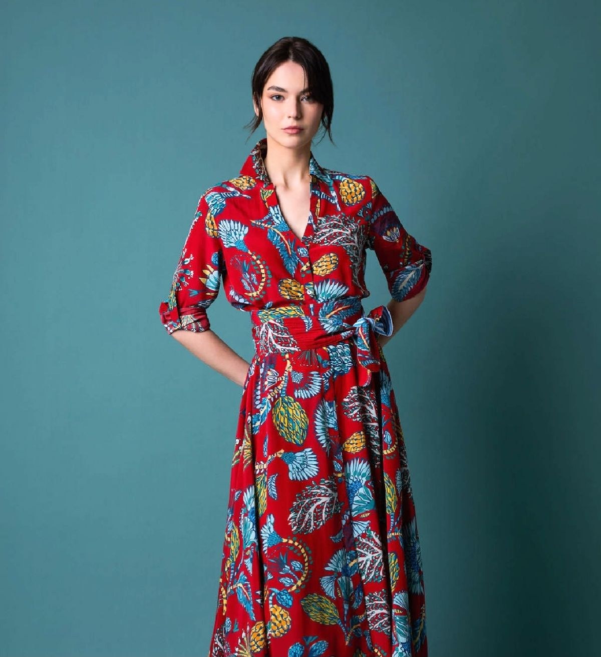 A model wearing a red printed The Tangerine Road dress