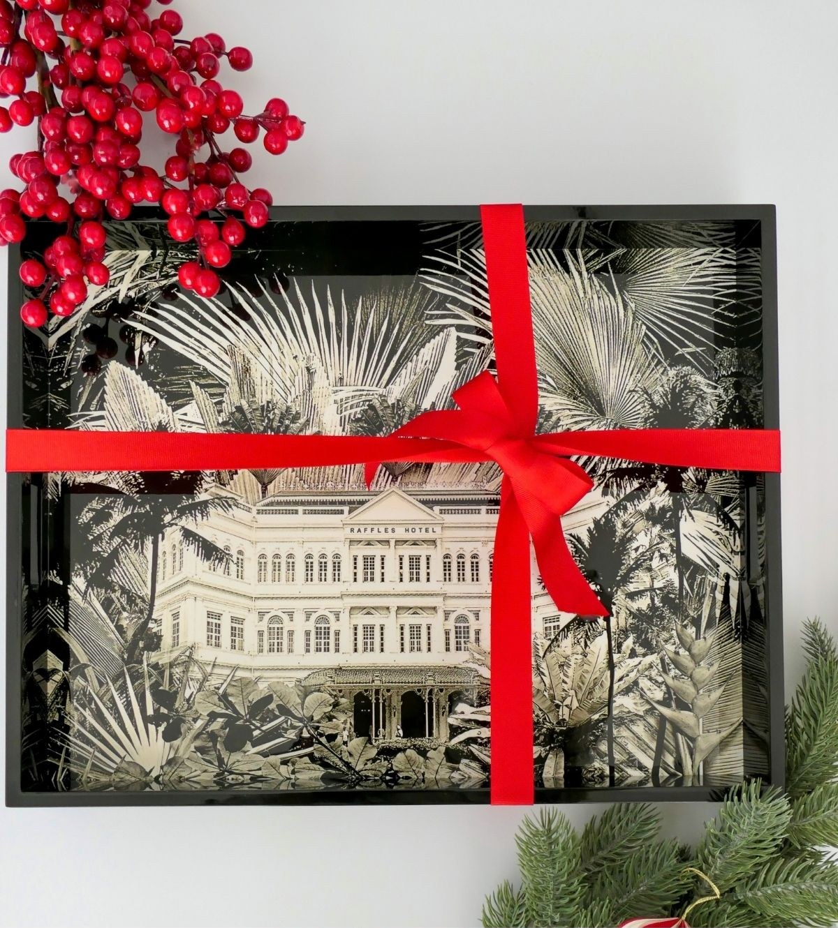 A Memory Boards keepsake box featuring the Raffles Hotel, tied with a red ribbon