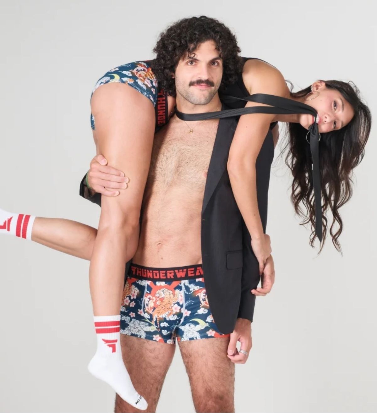 A couple wearing printed Thunderwear underwear and striped socks