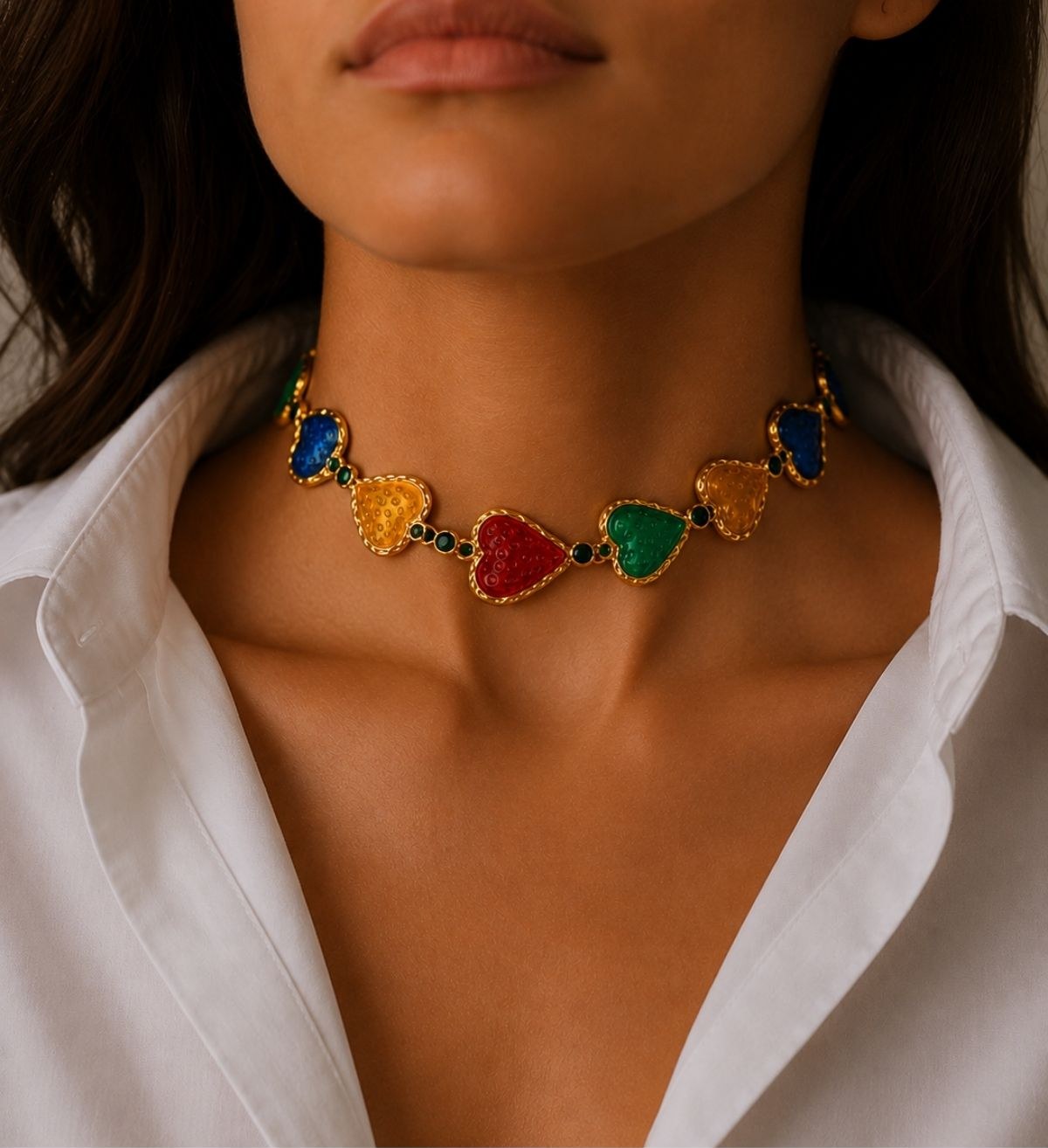 A woman wearing a colourful jewelled heart-shaped necklace with a white shirt