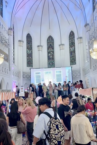 A packed aisle of shoppers beneath the vaulted ceiling and stained glass windows