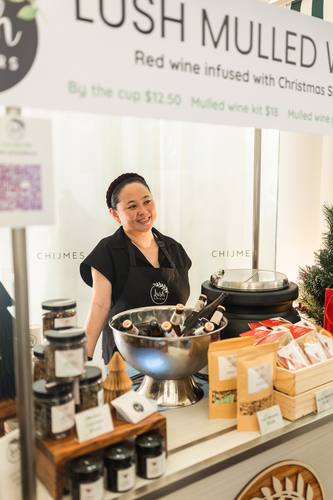A vendor pouring mulled wine at a Christmas stall