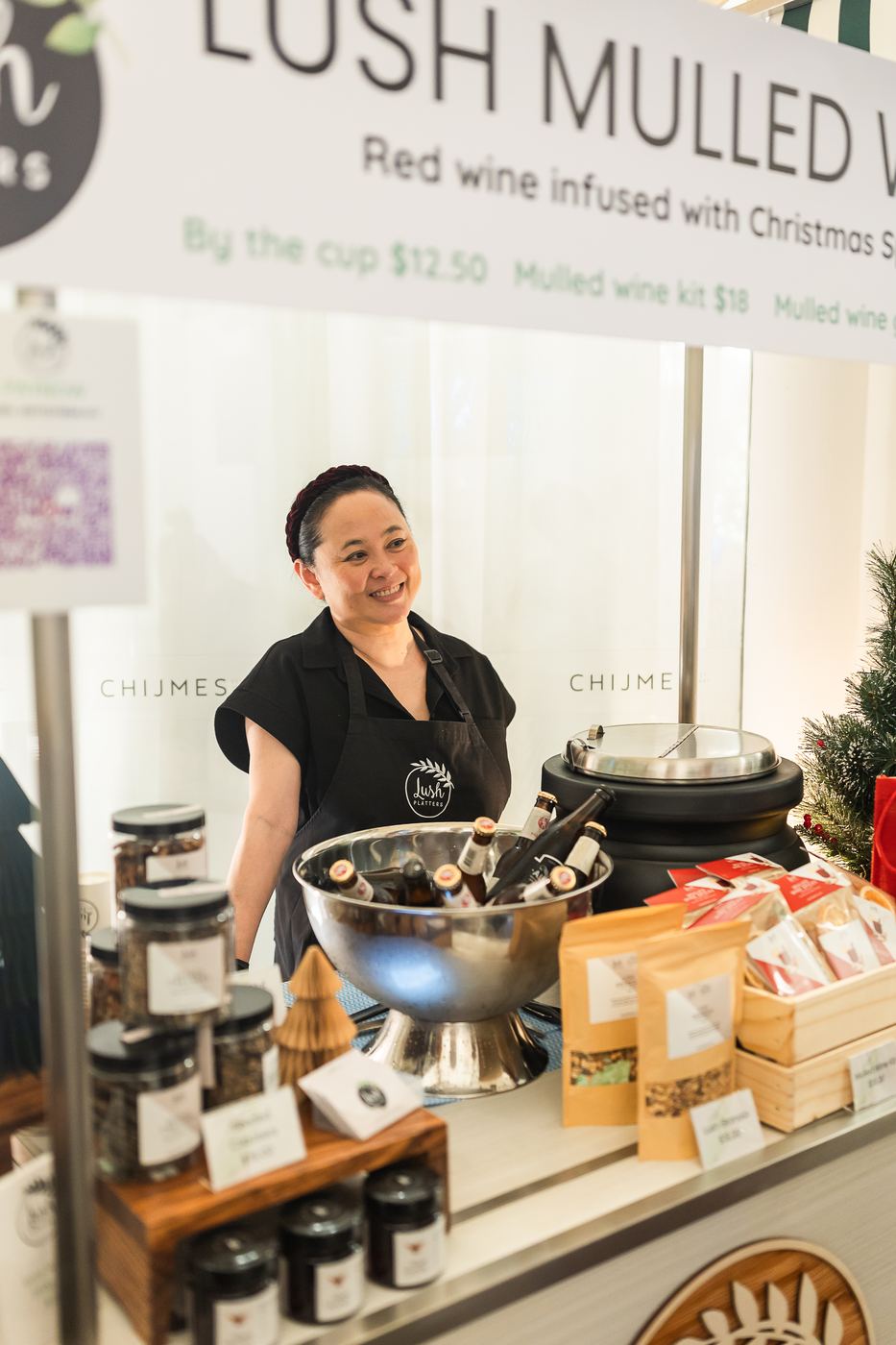 A vendor pouring mulled wine at her stall