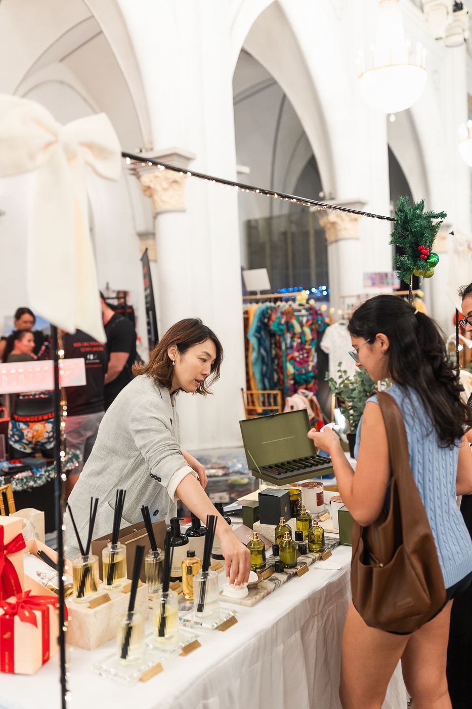 A shopper trying a fragrance at a perfume stall