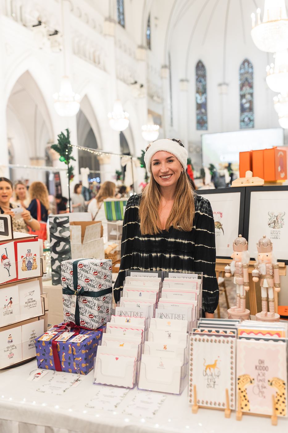 A vendor in a Santa hat at her stationery stall