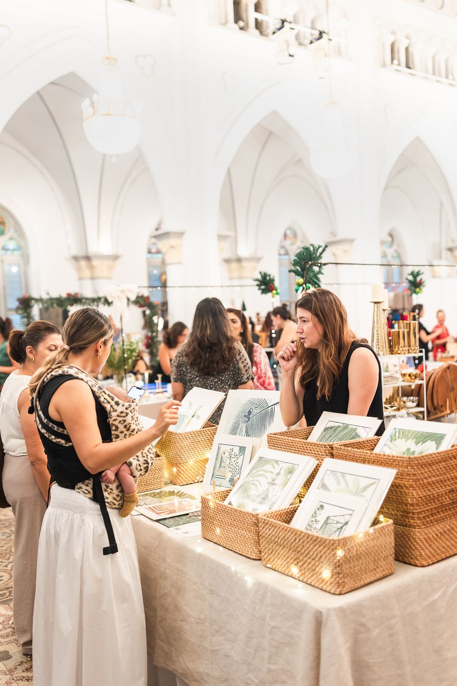 Shoppers looking through framed art prints in woven baskets